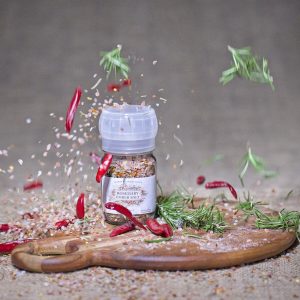 Bottle of Rosemary Ember Salt in a glass grinder with rosemary herb and sea salt blend